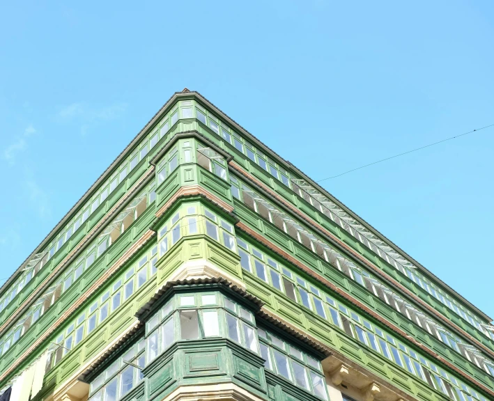 there is a tall green building with windows