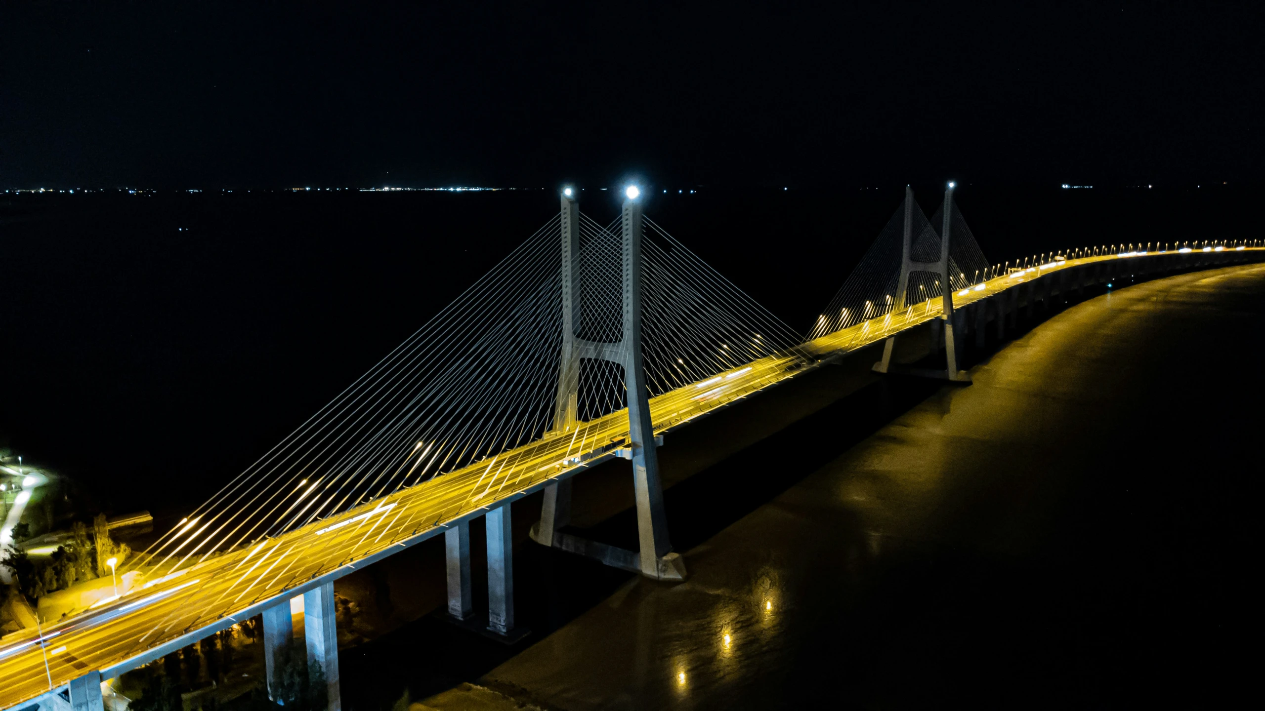 light trails across a bridge on the water