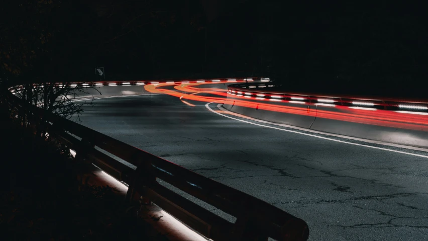 a street filled with cars driving by at night