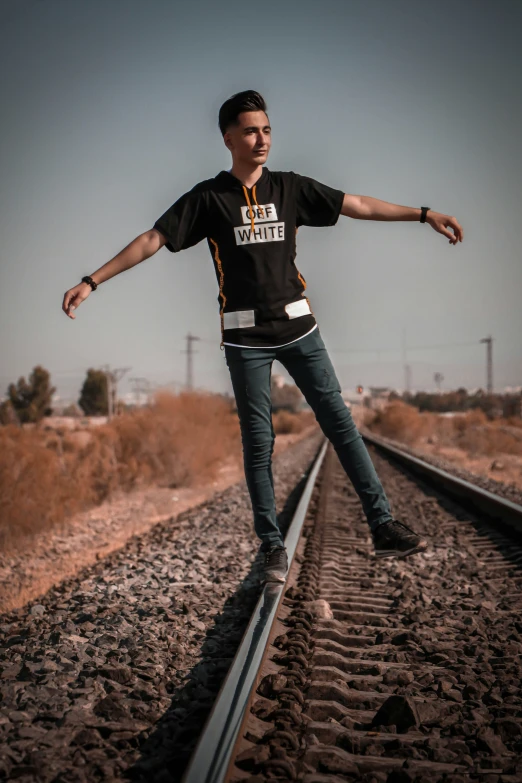 a man riding a rail road track in the middle of the day