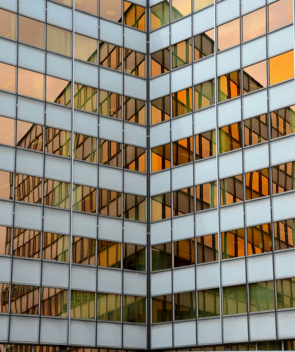 a very tall building with many glass squares reflecting its reflection