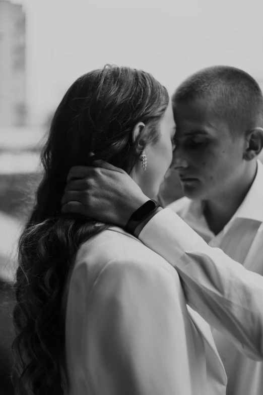 a couple hugs each other outside in a black and white po