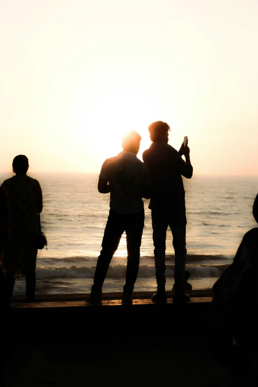 the silhouette of two people and one person on a beach