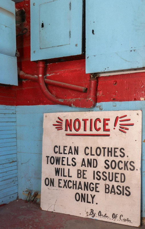 an old sign is posted by the blue door