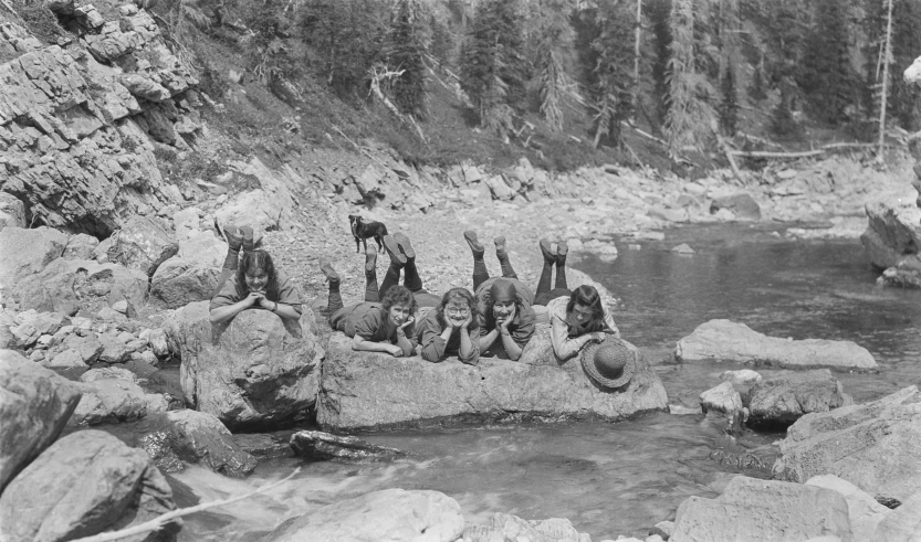 old pograph of a group of s standing on rocks in a stream