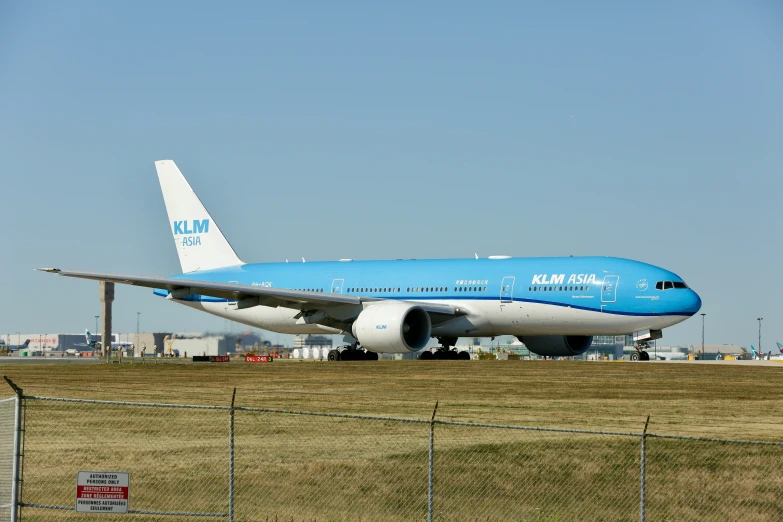 the blue airplane has landed on the runway
