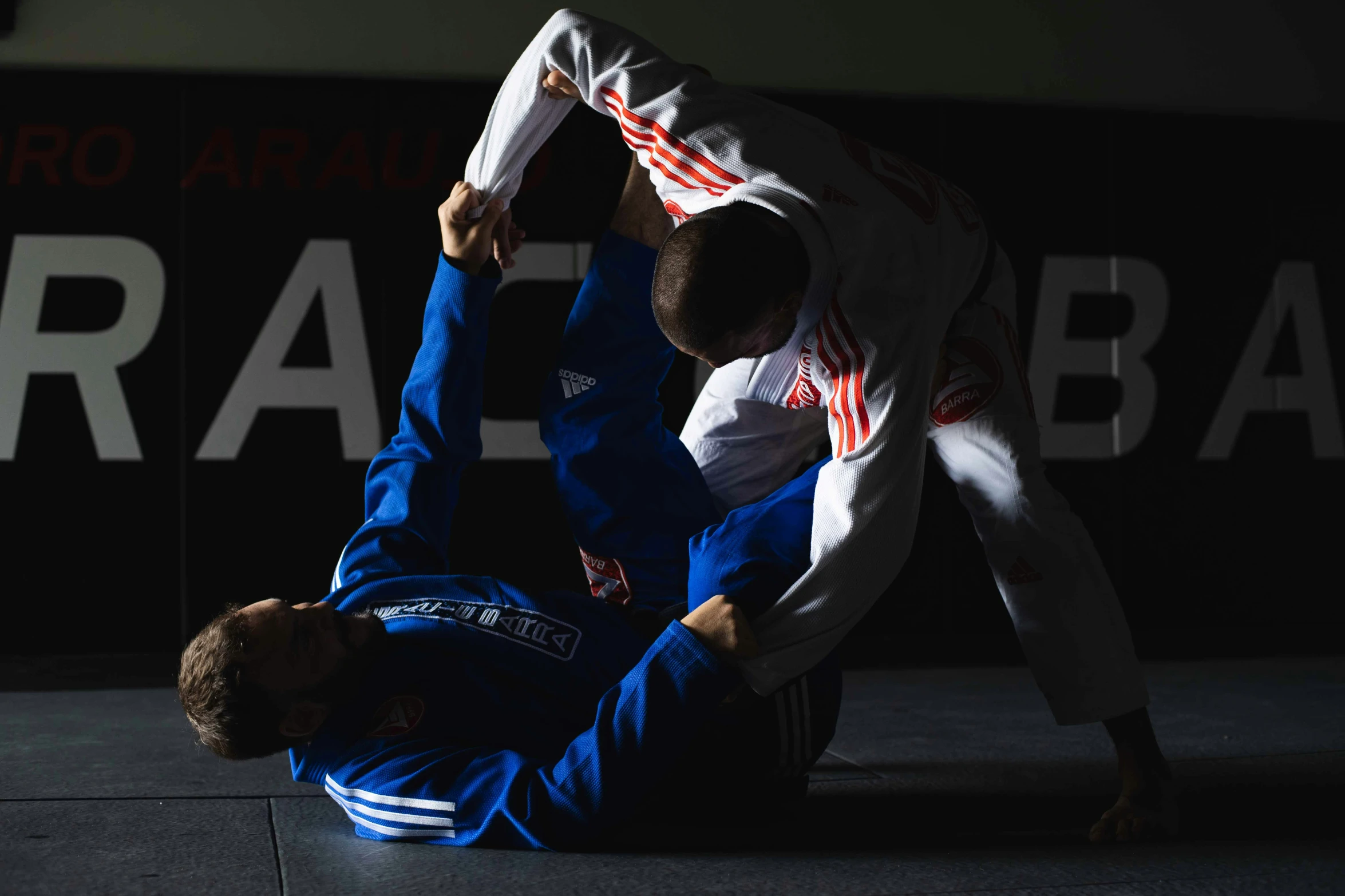 two men perform a side control kick from a kickbox