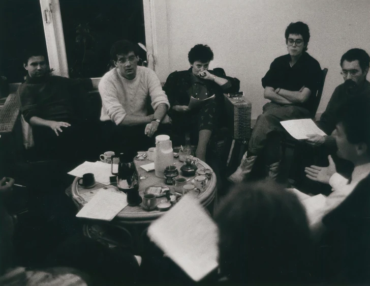 a black and white po shows a group of people around a table