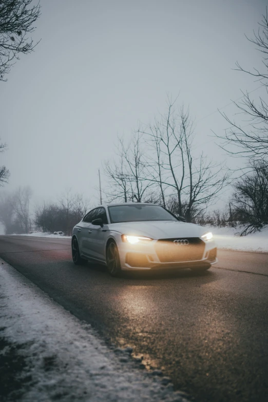 an automobile driving on a snowy road at night