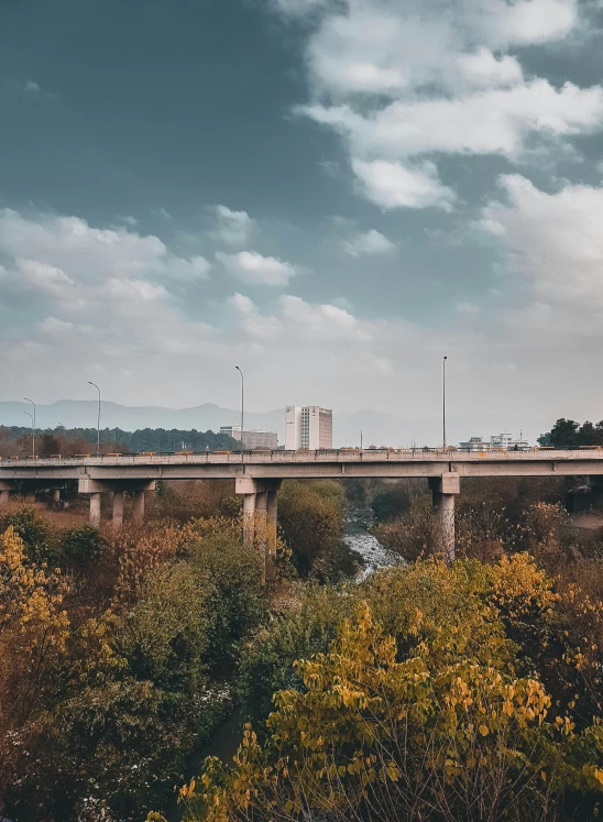 a cloudy blue sky over a bridge spanning a river