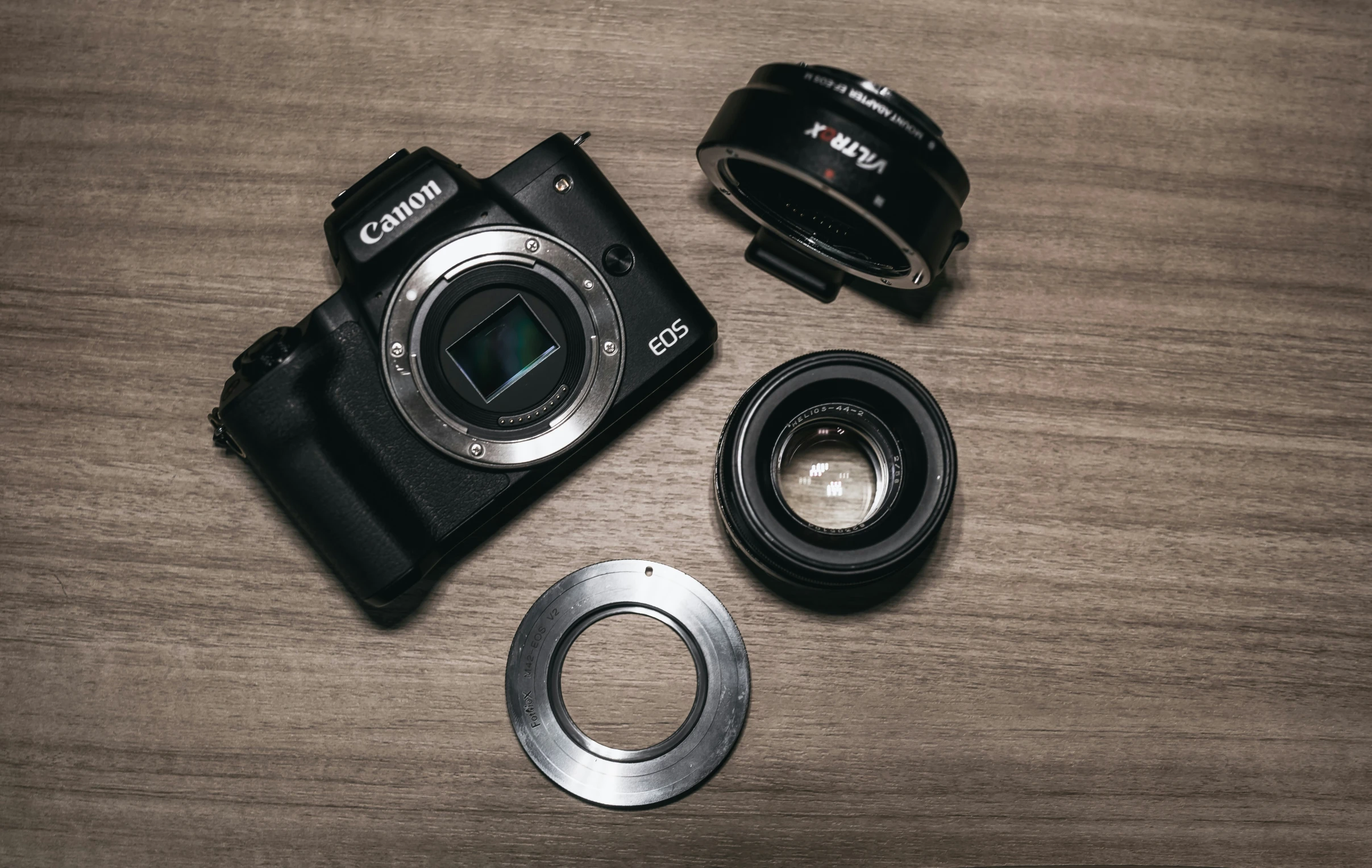 a camera and lens cap sitting on top of a wooden table