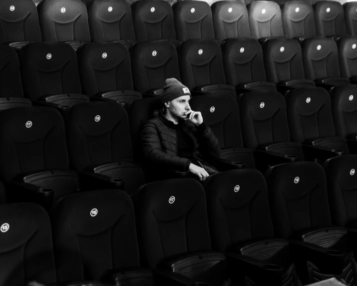 a man sitting in a black stadium seat