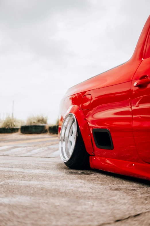 a close - up po of the front fender of a red car