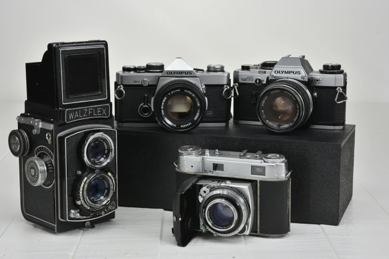 three antique cameras are sitting on display together