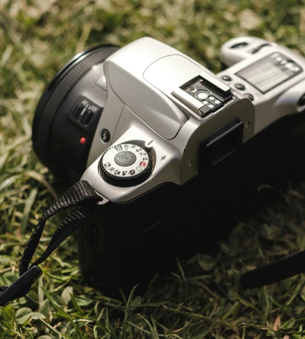 a camera is in the grass with a cord on it