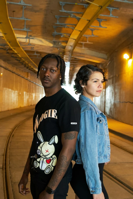 two people standing next to each other in a tunnel