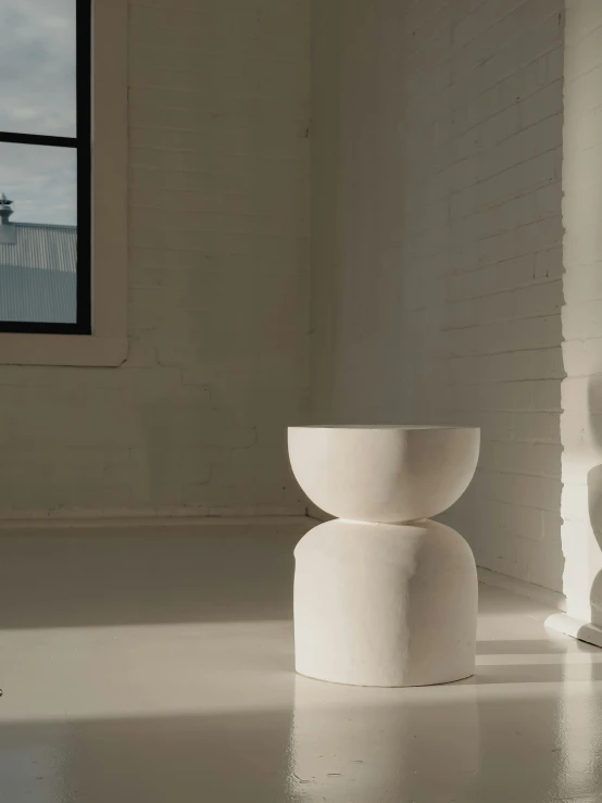 a white sculpture stands in a room next to a window
