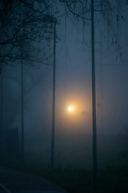 a foggy street at night with street lights