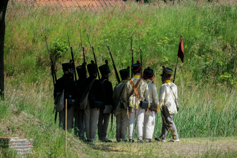 a group of men in uniforms standing next to each other with guns