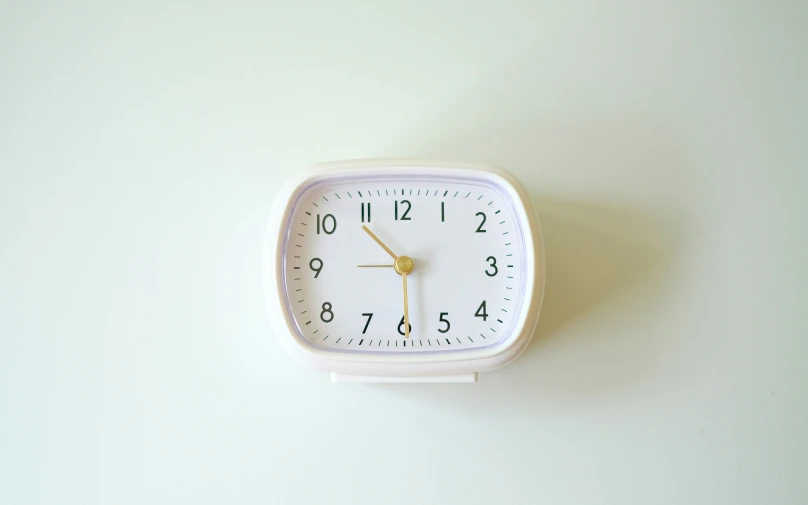 an alarm clock mounted to the wall shows the time in minutes