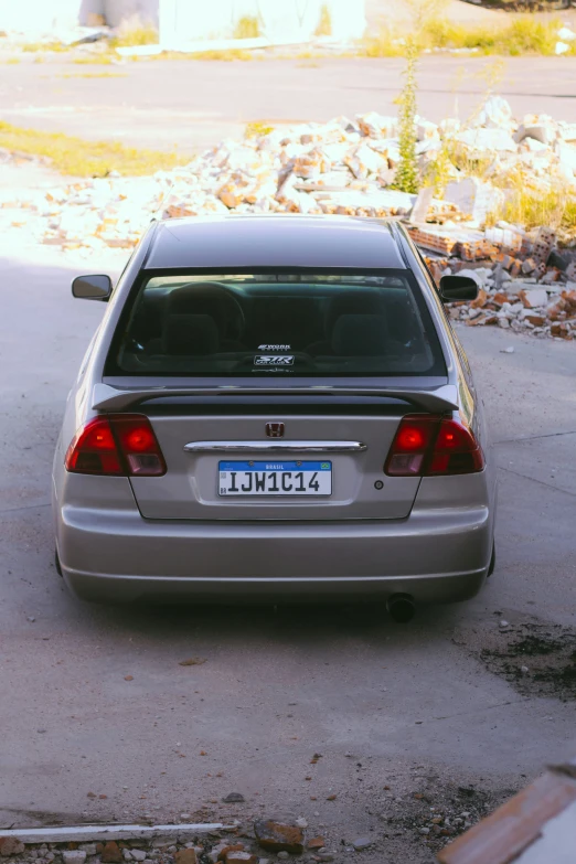 the back end of a parked car that is in front of some rubble