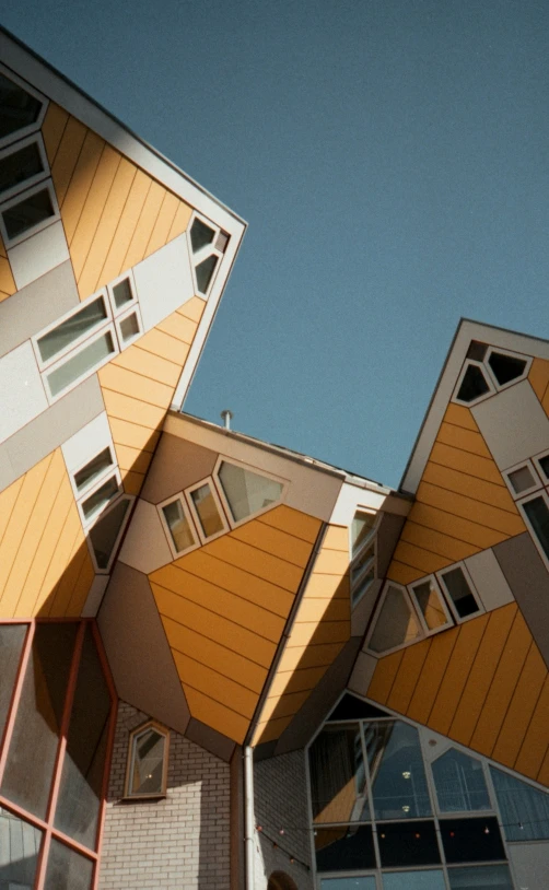 an upward perspective of three buildings that are yellow and brown