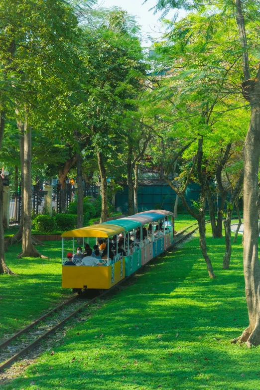 a small train going through the park on tracks