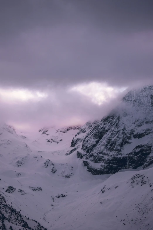 a cloudy sky over mountains covered in snow