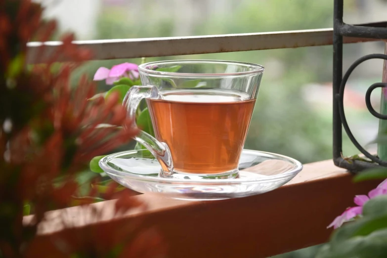 a glass tea cup filled with liquid on a saucer