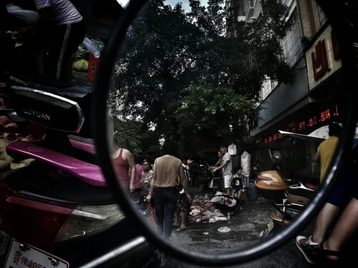 people standing around outside near a large mirror