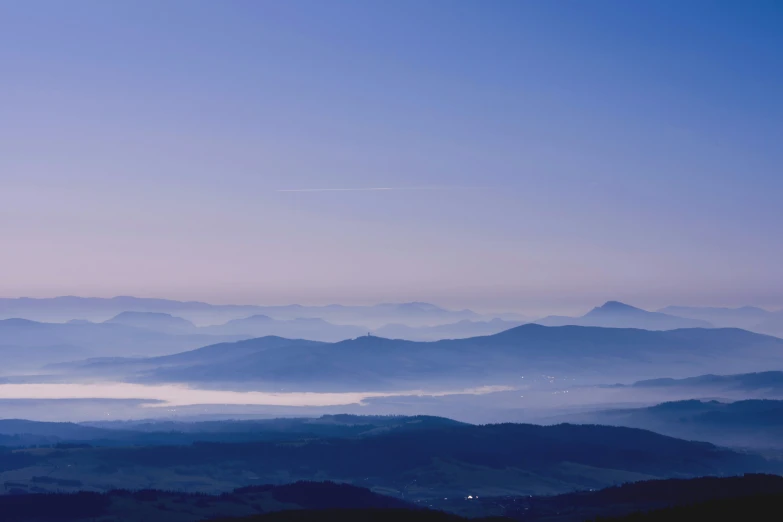 an airplane flying over a mountain range with the hills