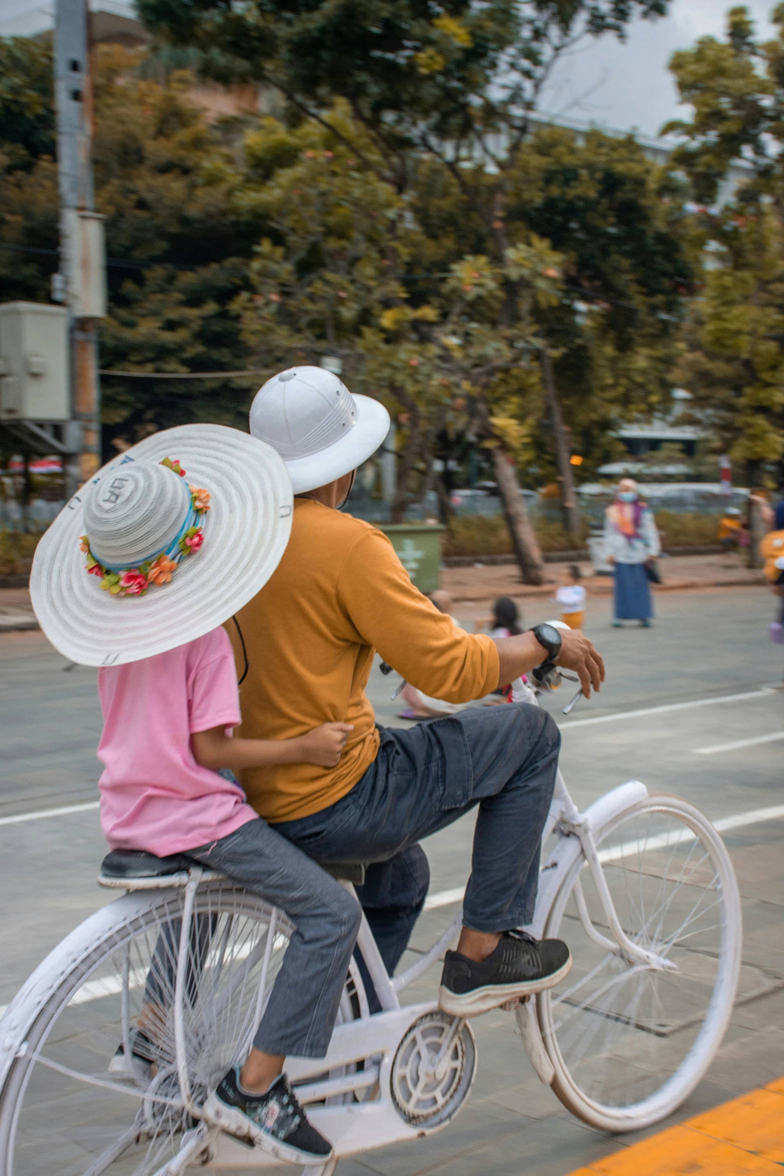 a couple rides down the street on a bicycle