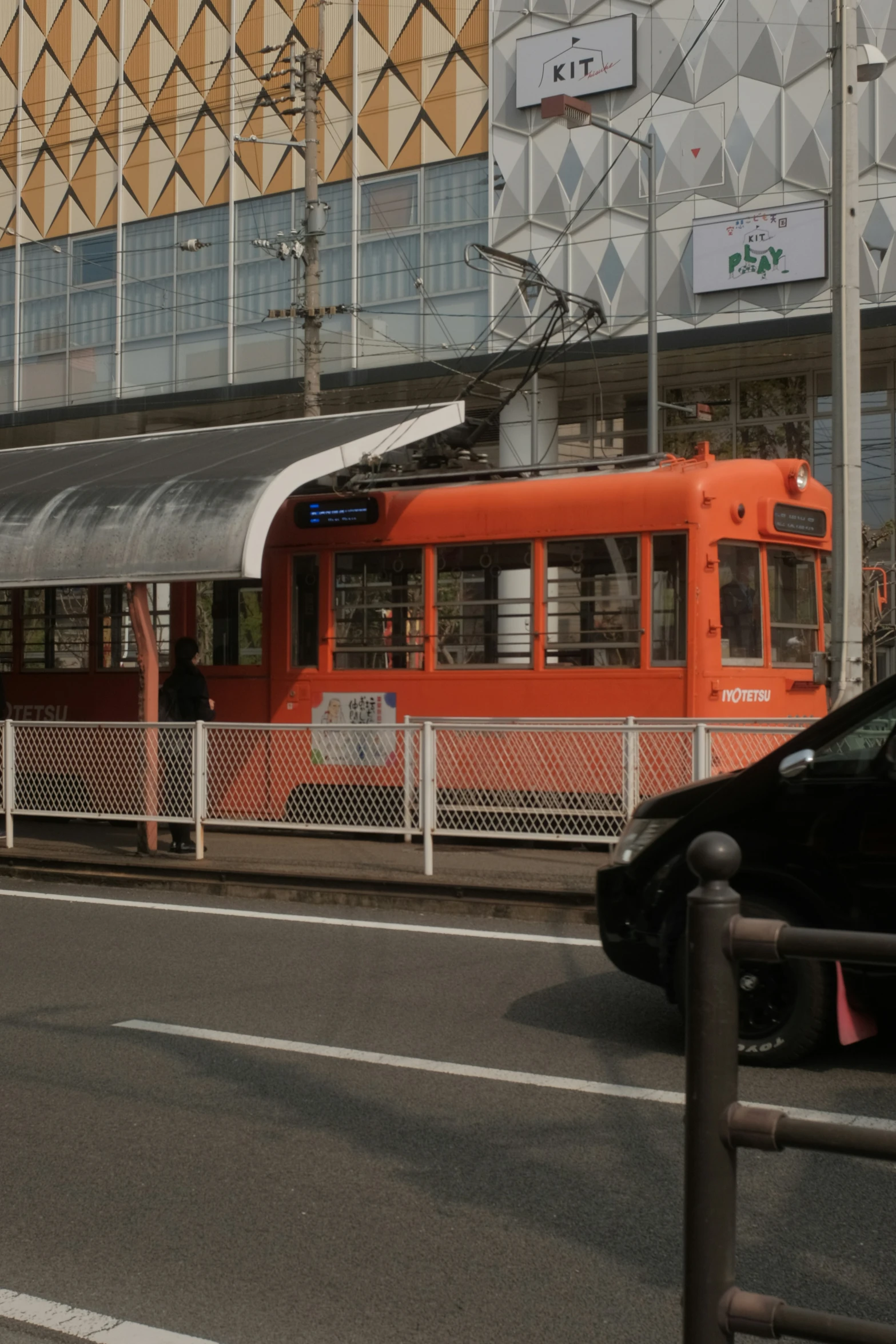 a train on tracks and cars near buildings