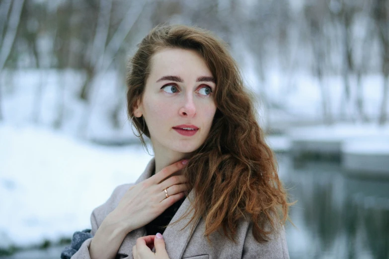 the young woman is wearing a coat and has a cold look on her face