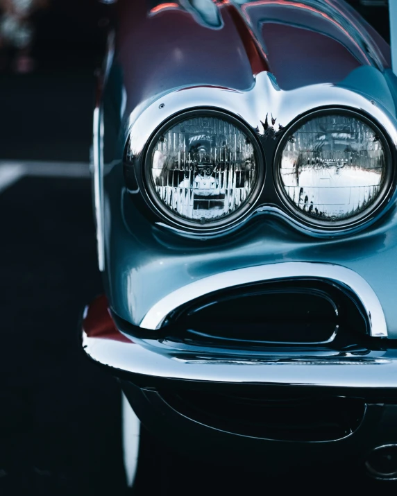 a close up of the front lights and the hood of an old car