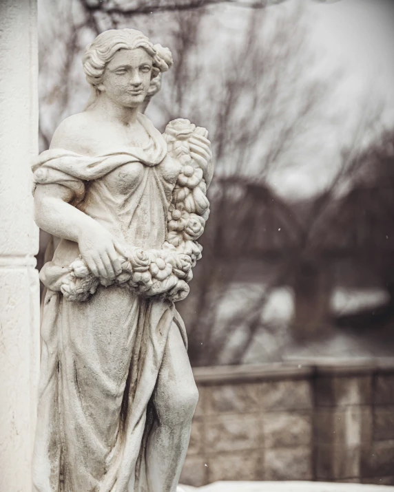 a statue in the shape of a female holding a fruit basket