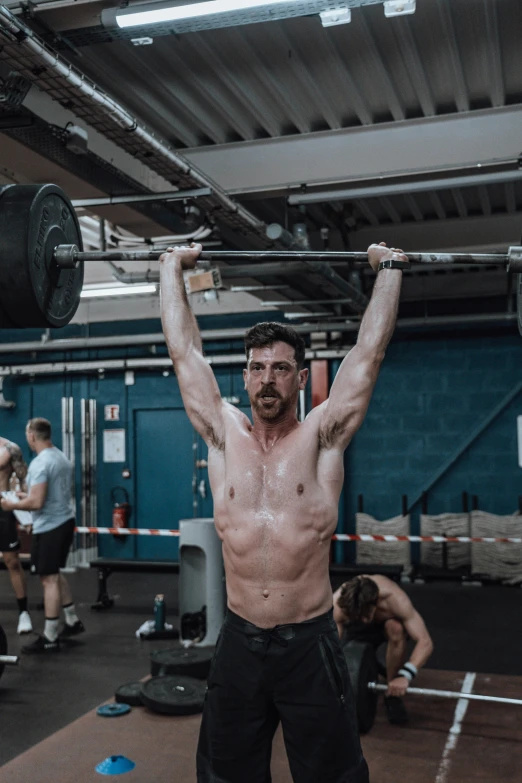 a man holding up his weight bar with one arm