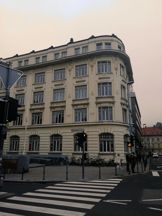 a building sitting on the corner with a cross walk in front of it