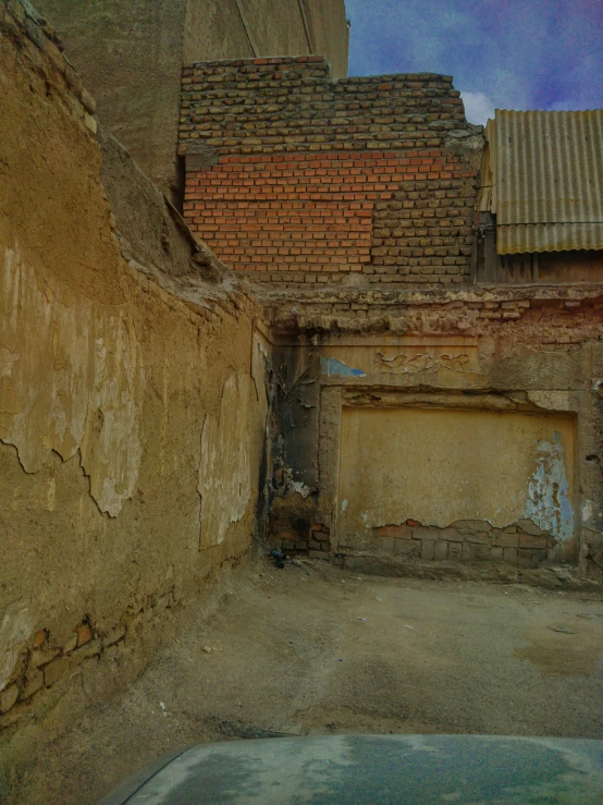 an old brick alley with a door and tiled roof