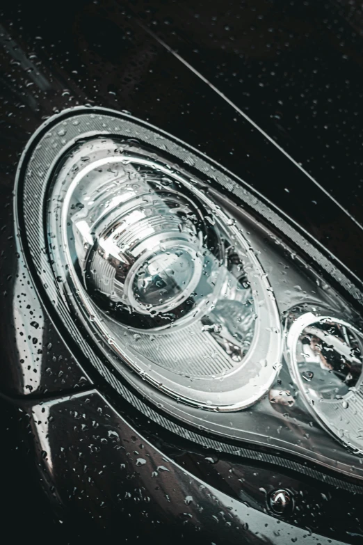 a close up of a shiny black car front headlight