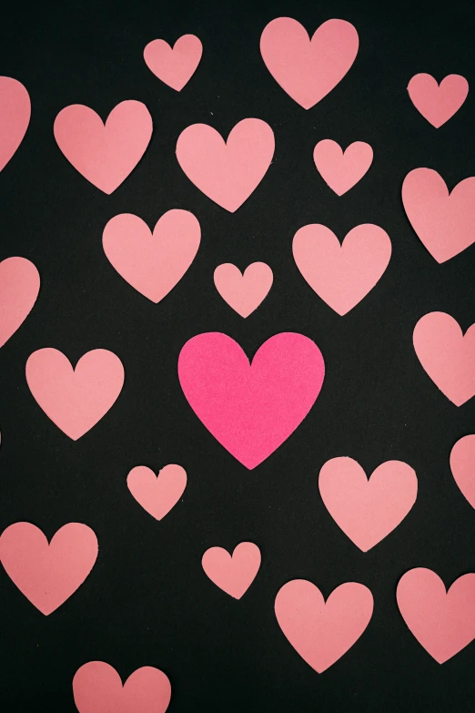 large group of pink hearts on black background