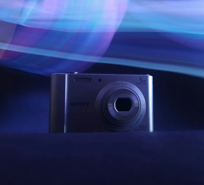 a camera sitting on a table with blue light behind it