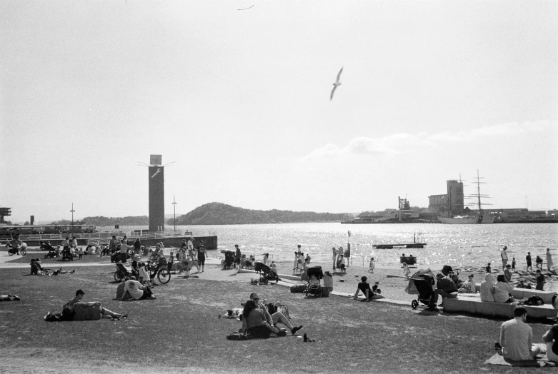 some people are relaxing at the beach near some buildings