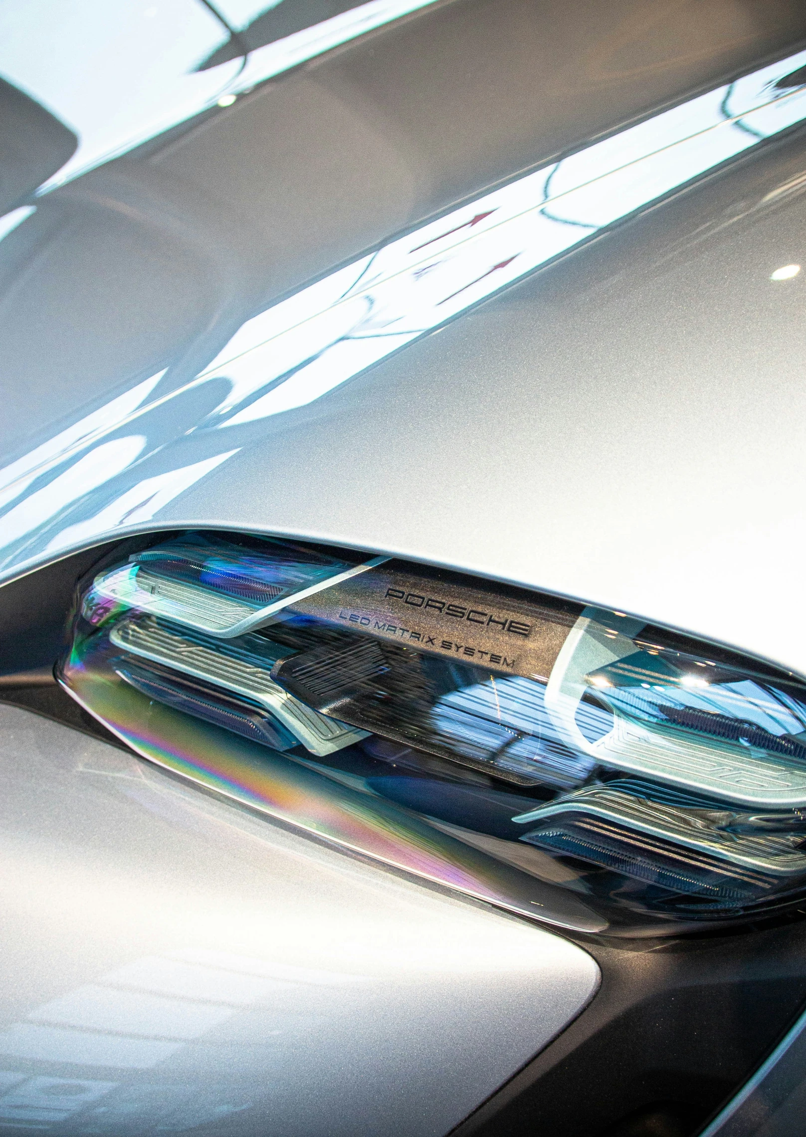 an unusual chrome hood or window and a car is reflected in the side mirror