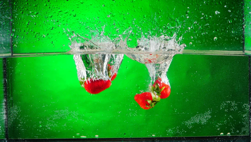 some strawberries in water with green background