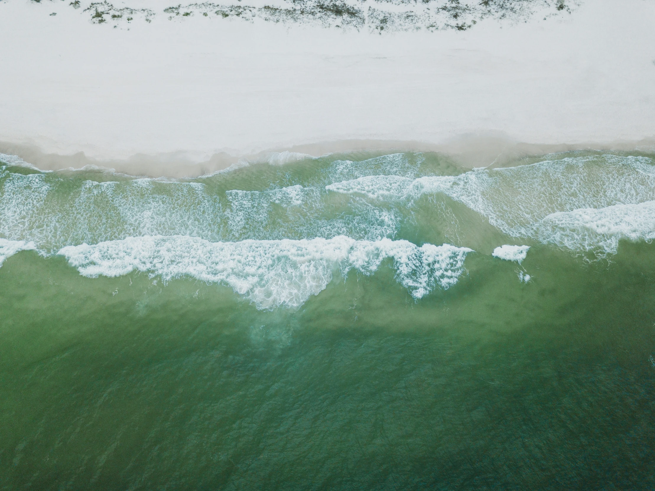 an aerial view of water and beach
