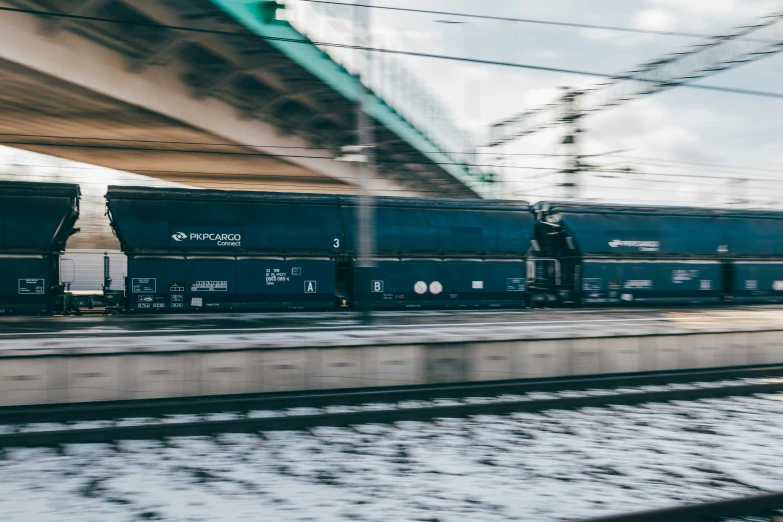 a train on a track beneath a bridge