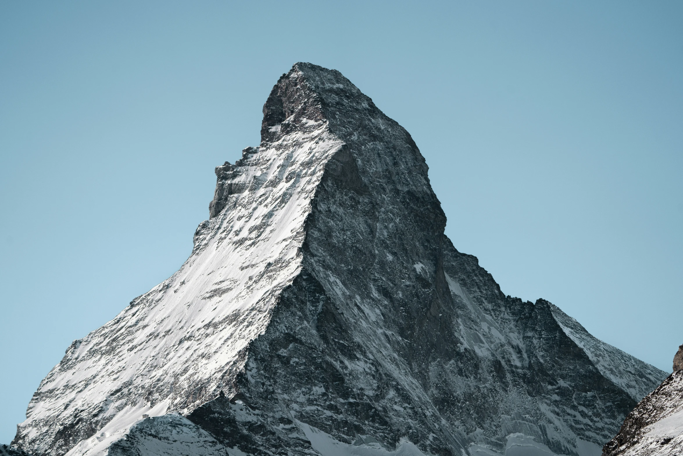 a snow covered peak against a clear blue sky