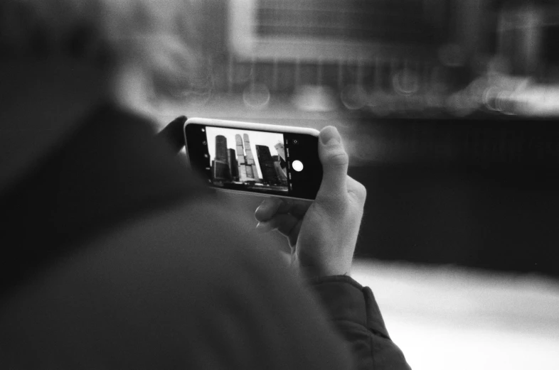 an older man holding his cell phone up to take a po