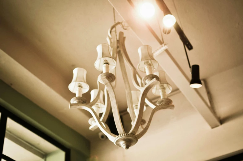 two chandeliers attached to the ceiling, one with light on